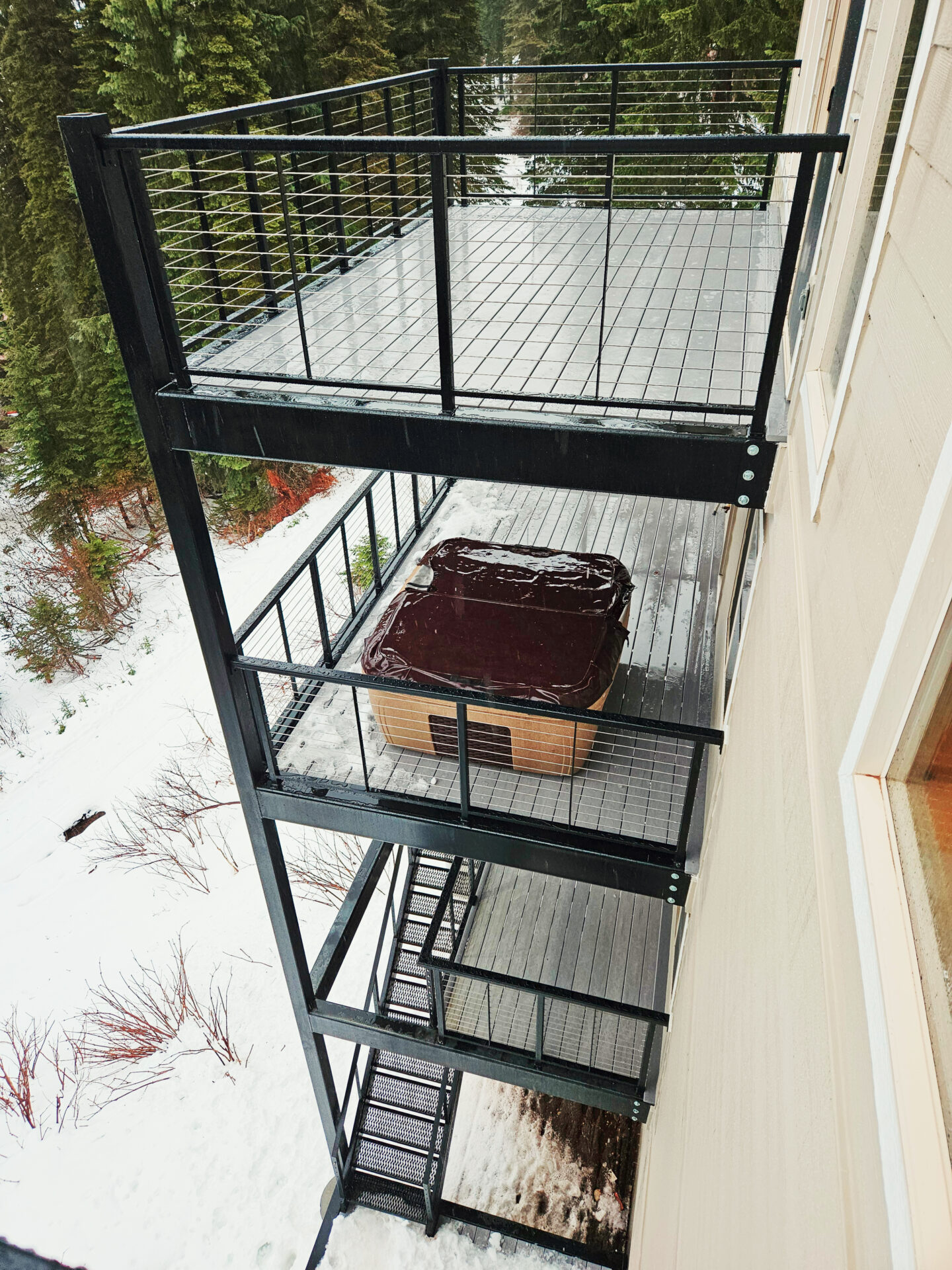 Custom balcony deck overlooking snowy landscape at Schweitzer Ski House by Blue Sky Decks.